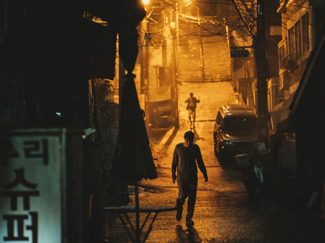 hombre caminando por una calle de China imagen película Parásitos
